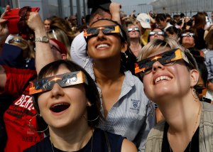 People watch the solar eclipse from the observation deck of The Empire State Building in New York
