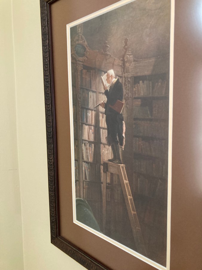 Picture of old man on ladder in large library